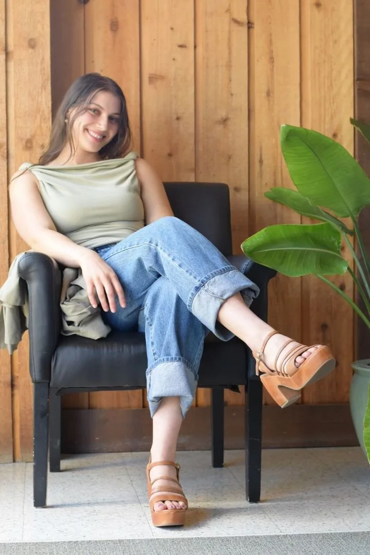 Talya Matz sitting in an armchair, smiling